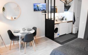 Apartamento pequeño con mesa, sillas y cocina. en La Clef d'Aurélia en Élancourt