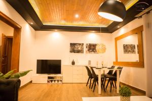 a dining room with a table and a television at Nandy's home in Odza II