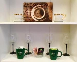 two shelves with cups and wine glasses on them at Cecilka in Náchod