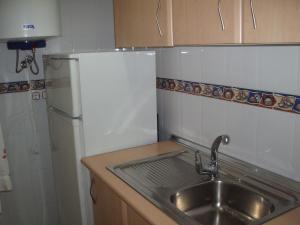 a kitchen with a sink and a refrigerator at Apartahotel Los Hermanos in Ocaña