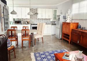 eine Küche mit weißen Schränken sowie einem Tisch und Stühlen in der Unterkunft Misty View in Doring Bay