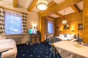 Hotel garni Almenrausch und Edelweiss في غارميش - بارتنكيرشين: غرفة معيشة بها أريكة وتلفزيون