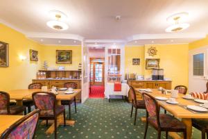 Hotel garni Almenrausch und Edelweiss في غارميش - بارتنكيرشين: مطعم فيه طاولات وكراسي في الغرفة