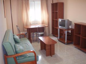 a living room filled with furniture and a tv at Apartahotel Los Hermanos in Ocaña