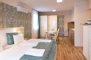 a bedroom with a white bed and a table with chairs at Főtér Rezidencia in Győr