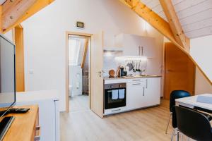 a kitchen with white cabinets and a stove top oven at Strandpension Mäder in Uhldingen-Mühlhofen