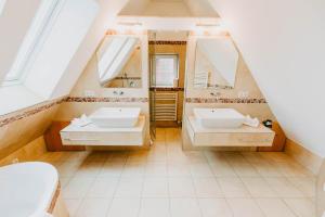 ein Badezimmer mit zwei Waschbecken und zwei Spiegeln in der Unterkunft Strandpension Mäder in Uhldingen-Mühlhofen