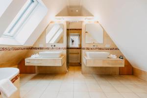 ein Badezimmer mit zwei Waschbecken und zwei Spiegeln in der Unterkunft Strandpension Mäder in Uhldingen-Mühlhofen