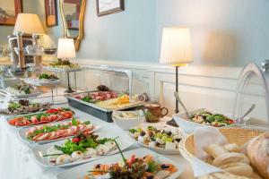 a buffet with many plates of food on a table at Hotel Dwór Kościuszko in Krakow
