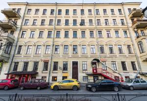 a large building with cars parked in front of it at F12 Apartments in Saint Petersburg