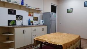 a kitchen with a table and a refrigerator at Guest House Sharq 21 in Khujand