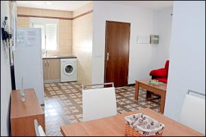 cocina y sala de estar con mesa y cocina en Chalet Muelle Pesquero 66, en Conil de la Frontera