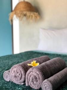 a purple towel with a yellow flower on a table at Captain Goodtimes in Gili Air
