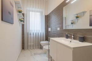 Linda House في بيسكارا: حمام مع حوض أبيض ومرحاض