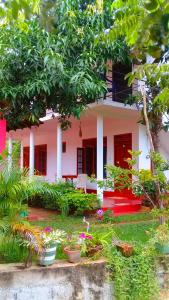 a pink house with plants in front of it at Mountain Heaven inn in Mirissa
