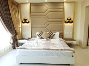 1 dormitorio con 1 cama blanca grande en una habitación en Hotel Avalon Suites, en Multán