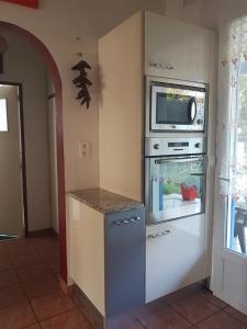 eine Küche mit einem Backofen und einer Mikrowelle in der Unterkunft Grande maison de vacances in Lévignacq