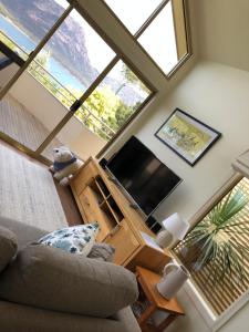 a living room with a couch and a large window at Freycinet Beach House in Coles Bay