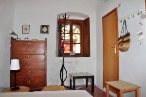 um quarto com uma cama, uma cómoda e uma janela em Old Traditional House in the Castle of Monenvasia em Monemvasia