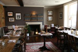 a restaurant with tables and chairs and a fireplace at The Swan Hotel, Alresford in Winchester