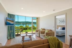 een woonkamer met een bank en een bed bij Cetacea Luxury Apartments in Merimbula