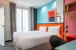 a hotel room with a large bed and a desk at Hotel Pilime in Paris +37 photos