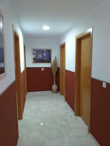 a hallway with two doors and a vase at Hostal Monteluna in Rociana