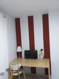 um quarto com riscas vermelhas e brancas na parede em Hostal Monteluna em Rociana