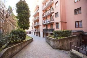 una calle vacía frente a un edificio rosa en GuestHost - Studio con Balcone per 2 persone, en Milán