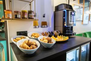 a counter with bowls of food on a table with a coffee maker at Hotel Pilime in Paris