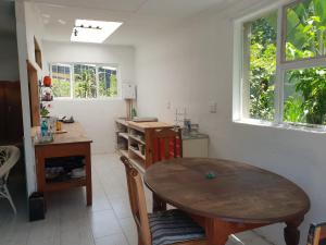 a kitchen with a wooden table and a table and window at Bamboo, the Guesthouse in Knysna