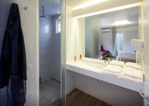 a bathroom with a sink with a mirror and a shower at Fabulous village in Casal Palocco