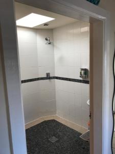 a bathroom with a shower with white tiles at Beautiful Wales in Barmouth +74 photos