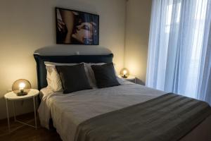 um quarto com uma cama grande com 2 mesas e 2 candeeiros em LOTOS HOUSE em Atenas