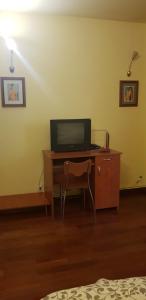 um quarto com uma secretária e uma televisão em Hospitality Centrum - Magheru em Bucareste