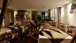 een restaurant met tafels en stoelen en een plant bij Hosteria Actinia in Villa Gesell +19 foto's