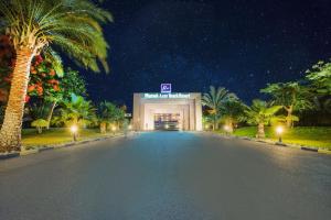 an empty road in front of a building with palm trees at Pharaoh Azur Resort in Hurghada