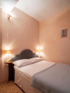 een slaapkamer met een bed met twee verlichting bij Ca’Molin in Venetië