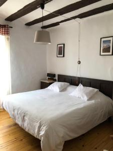 a bedroom with a large bed with white sheets at Casa Coll in Barruera