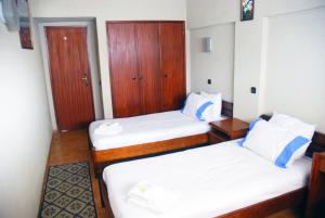 een kamer met 2 bedden en een kast bij Tubarinho Apartment in Costa da Caparica