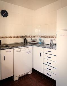 a small kitchen with white cabinets and appliances at Casa La Alegria De La Alcarria II in Sigüenza