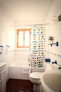 a bathroom with a tub and a toilet and a shower curtain at Casa La Alegria De La Alcarria II in Sigüenza