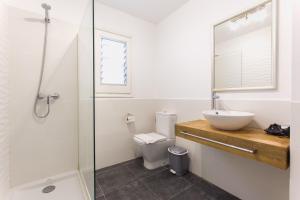 a bathroom with a sink and a toilet and a shower at Apartamentos Gama in Cala Galdana