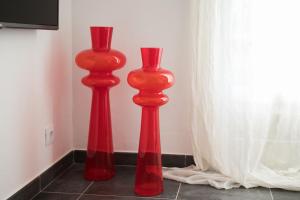 two red vases sitting on the floor next to a window at Apartamentos Gama in Cala Galdana