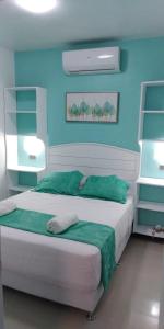 a bedroom with a white bed with blue walls at Villa Victoria in Sosúa