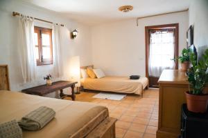 アロナにあるEl Cerro de la Lunaのベッド2台とソファが備わる客室です。