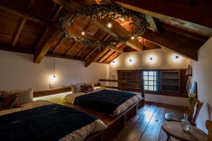 a bedroom with two beds in a room with wooden ceilings at The Bath & Bed Hayama in Hayama