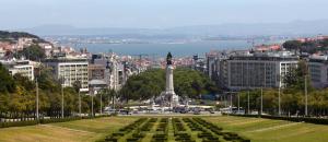 a view of a city with a statue in a park at A Ponte Marques de Pombal in Lisbon