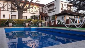 een huis en een zwembad voor een huis bij Hosteria Actinia in Villa Gesell