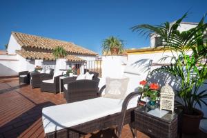 un patio con sofás, mesas y plantas en Apartamentos Casa del Aceite, en Córdoba